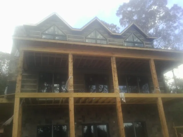 Dormers and porch framing on a large log home under construction — Roof Coating work by our crew in Hephzibah